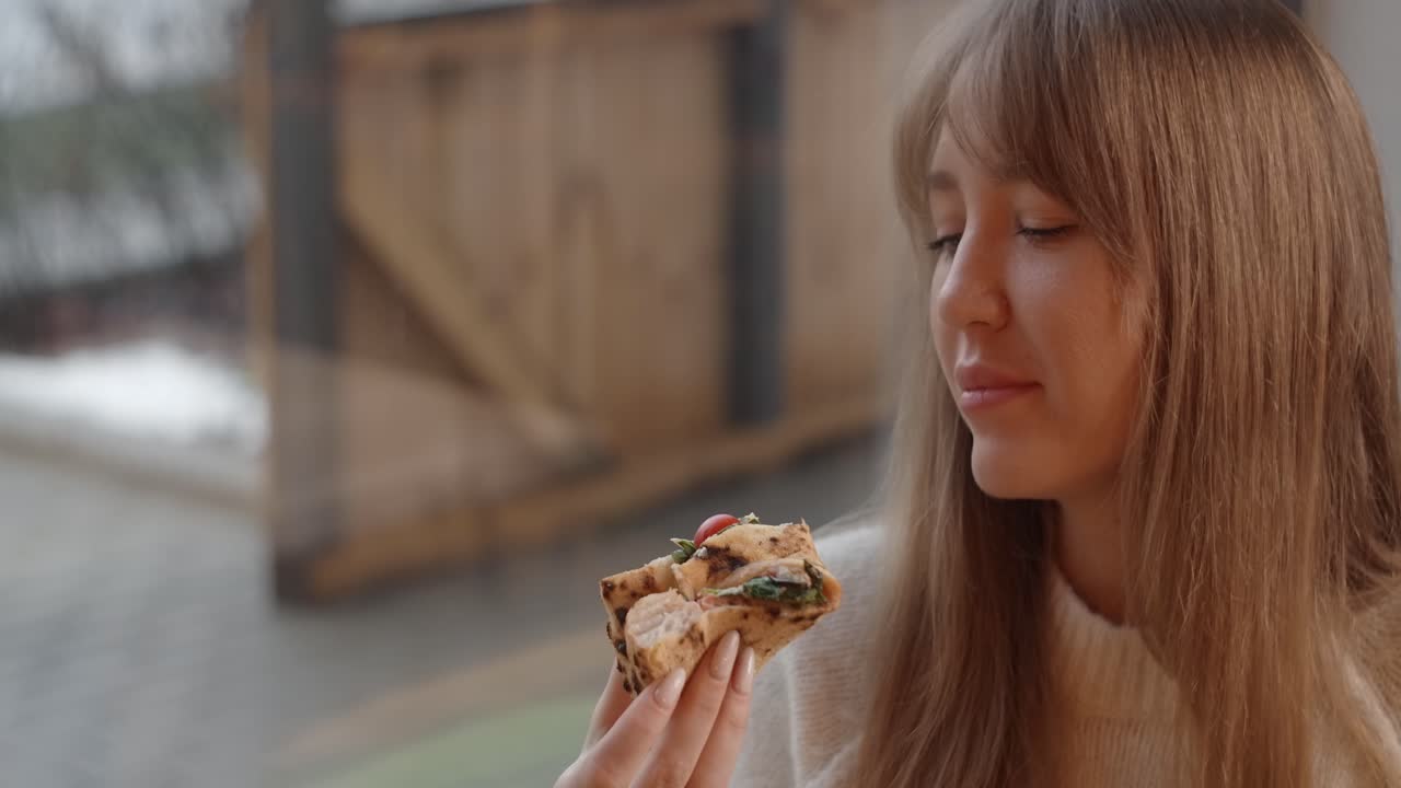 Woman enjoying a delicious pizza sandwich