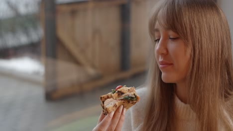 woman enjoying a delicious pizza sandwich