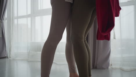 Downward view of instructor embracing client in studio as client remains grounded on nail pad during mindful bodywork session, emphasizing connection, and grounding experience in serene atmosphere