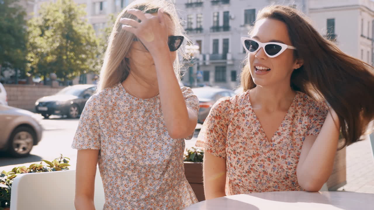 두 여자 친구 가 카페 에서 대화 를 즐기고 있다