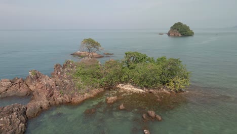 aerial birds eye view drone fly over shot of a small deserted tropical island in south east asia