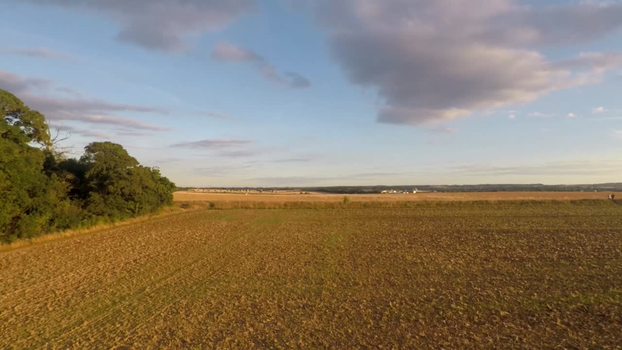 Slowly following the dense tree line before revealing beautiful goldern farmland