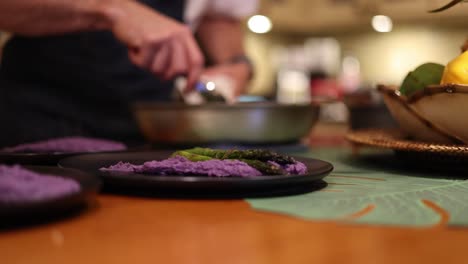 Chef-Colocando-Cuidadosamente-Un-Plato-Con-Espárragos-Usando-Pinzas-De-Plata