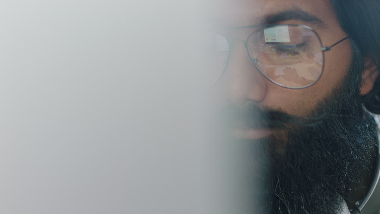 close up portrait young indian businessman using computer brainstorming browsing online research ideas for startup company project networking reading email wearing glasses in office