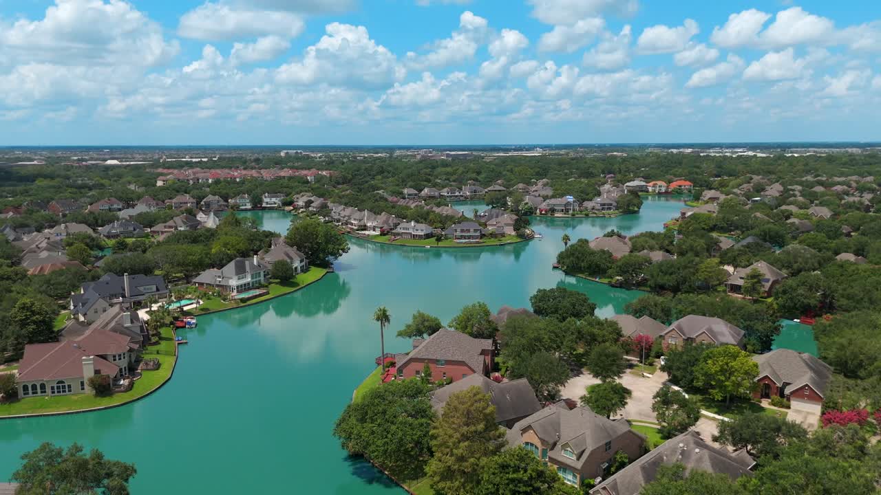 An aerial view of homes, located along a lake.