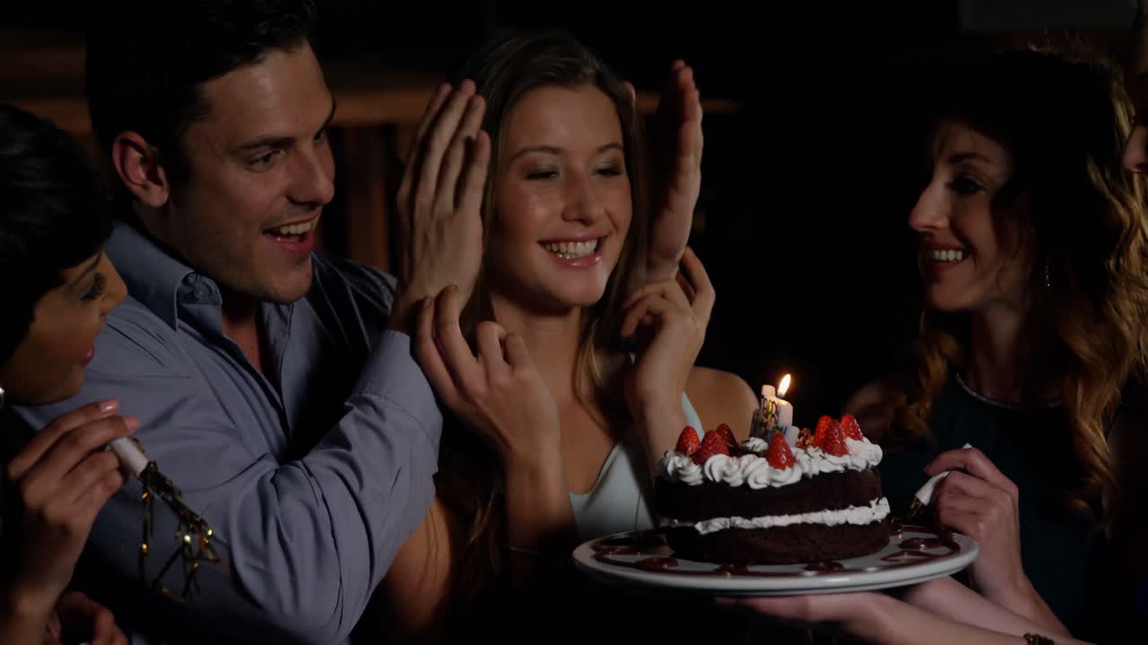 amigos celebrando una fiesta de cumpleaños sorpresa en un bar.