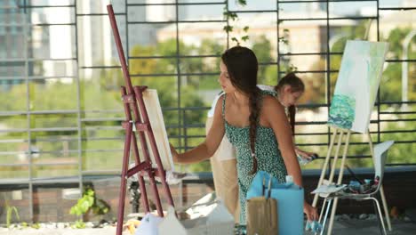 woman painting outdoors on a rooftop