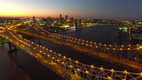 Hermosa-Noche-Toma-Aérea-Del-Puente-De-La-Ciudad-De-Crescent-Sobre-El-Río-Mississippi,-Revelando-El-Horizonte-De-Nueva-Orleans,-Luisiana