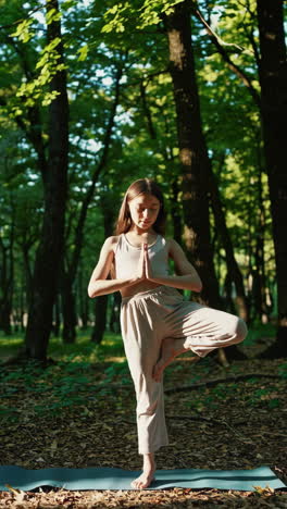 teen girl practicing yoga in the forest