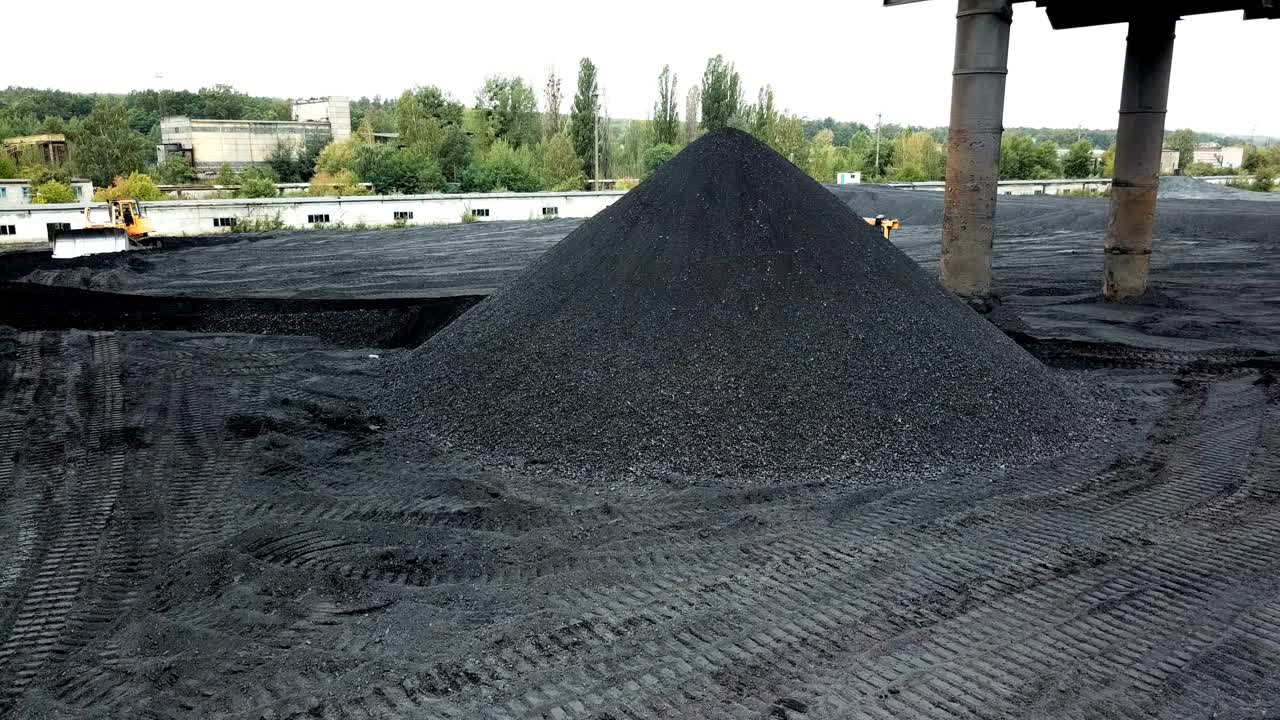 Bulldozer sorts coal. Extractive industry, anthracite. Coal industry. Aerial view.