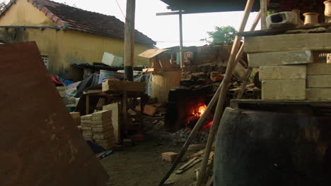 Eine-Töpferszene-In-Einem-Chaotischen-Thanh-Ha-Handwerksladen-In-Vietnam-Mit-Einem-Holzofen-Im-Hintergrund,-Der-Die-Kreativität-Traditioneller-Handwerkskunst-Zur-Schau-Stellt