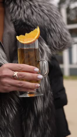 woman enjoying a warm drink outdoors in winter