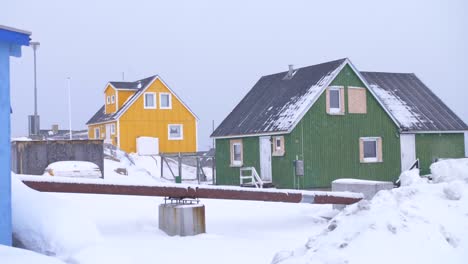 Slow-motion-pan-of-colourful-houses-in-a-snowstorm-in-Ilulissat,-Greenland