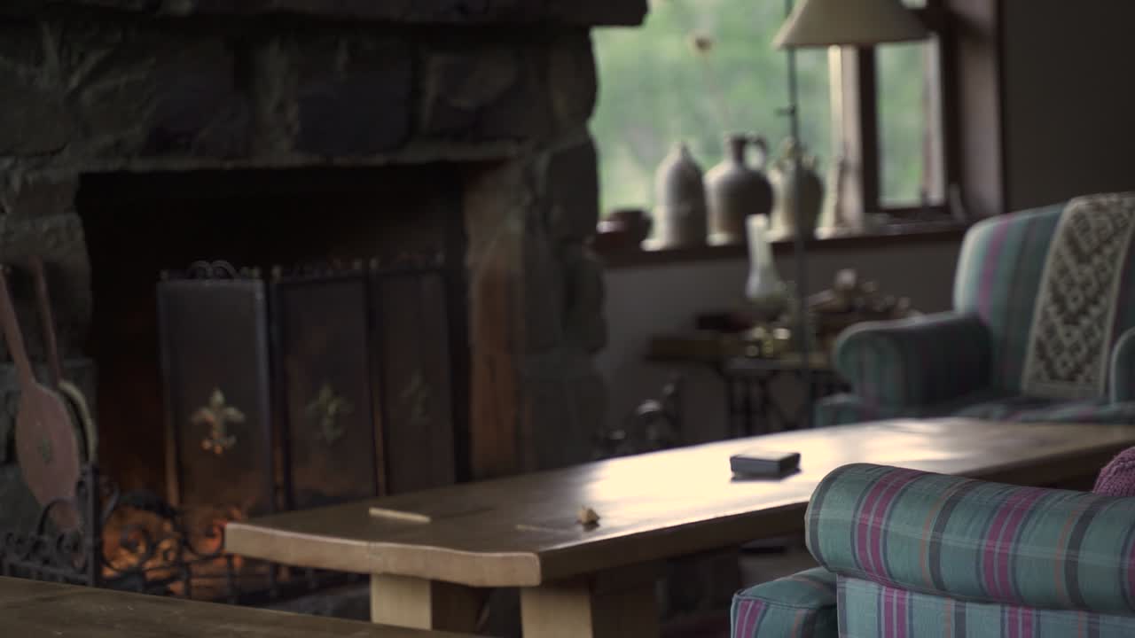 acogedora y elegante gran sala de estar con sofás, chimenea, pequeñas ventanas de mesa en casa de madera cámara lenta y 60 fps
