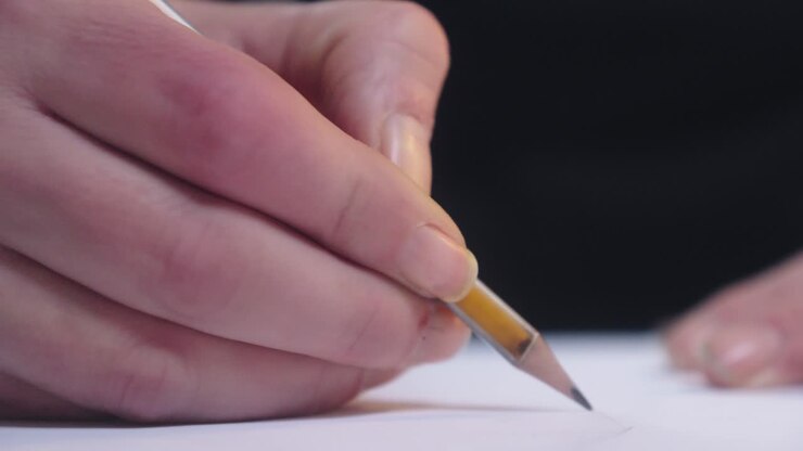 Close-up of a hand working with a pencil in a sketchbook