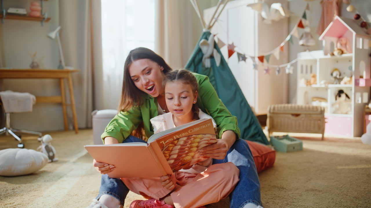 Figlioletta che sfoglia un libro con la madre in una stanza. La mamma legge una favola alla bambina
