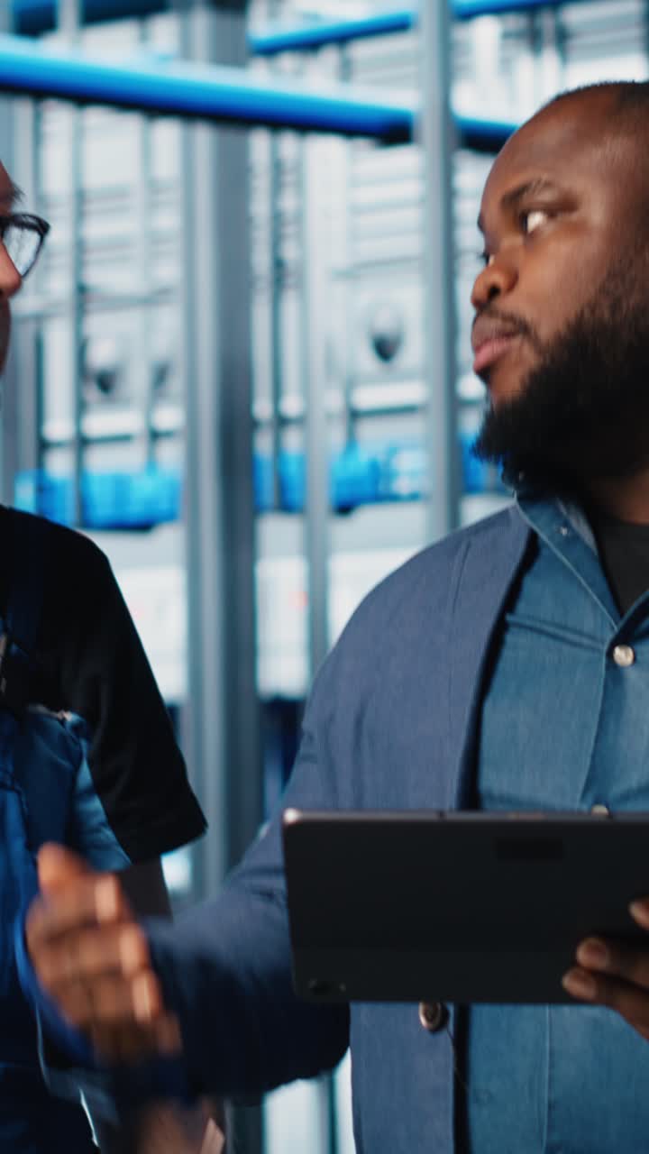 Video verticale: Colleghi del team di ingegneri di una smart factory che implementano flussi di lavoro automatizzati.