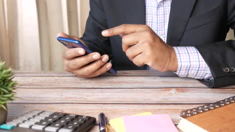 hombre de negocios usando un teléfono inteligente en su escritorio