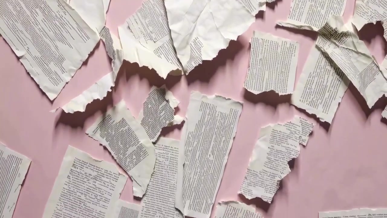 Scattered Torn Paper Pieces With Printed Text On A Pink Background