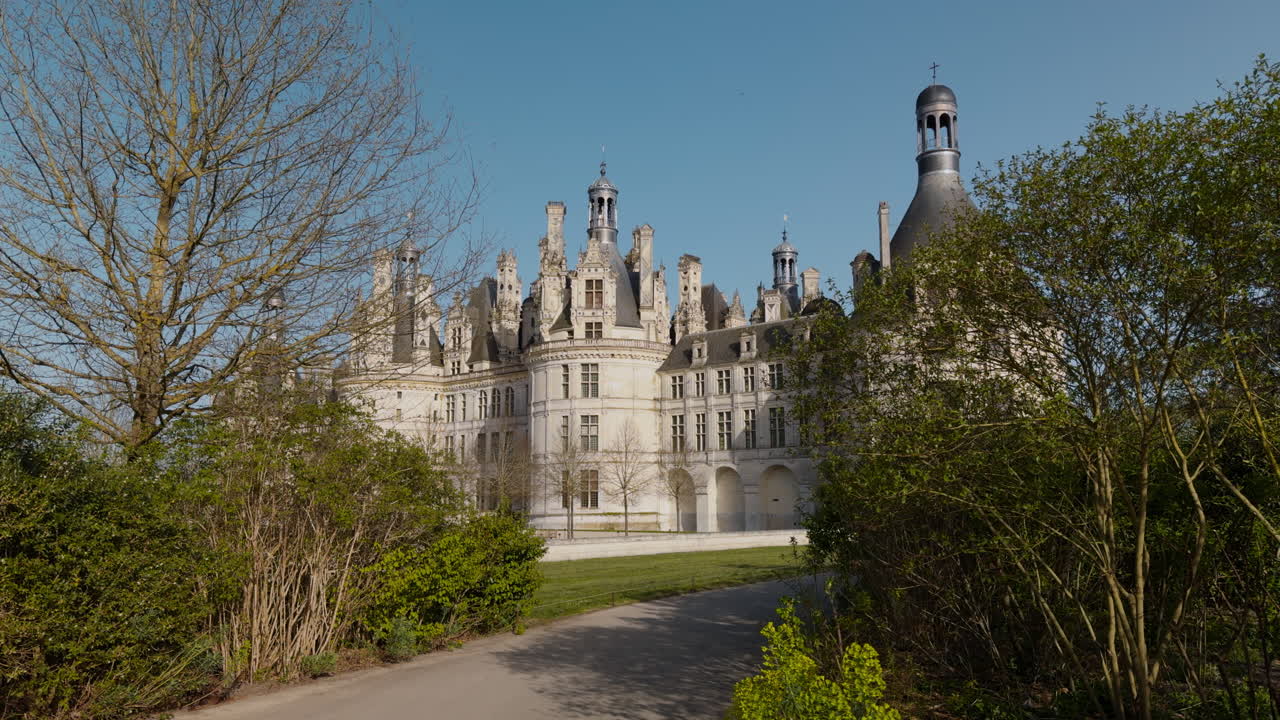 Royal castle in France, Chambord, seen through trees on a sunny spring day