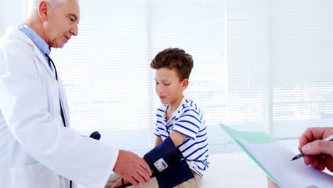 Male-doctor-checking-blood-pressure-of-patient