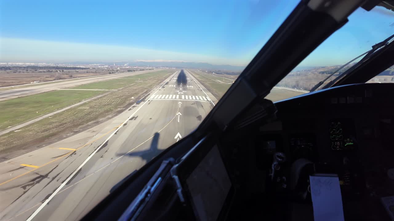 Vista immersiva della cabina di pilotaggio nella fase di avvicinamento finale all'aeroporto di Madrid tramite Pilot Window, con l'ombra del jet sulla soglia della pista 32R