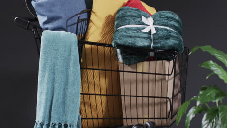 video of shopping trolley with shopping with copy space over grey background