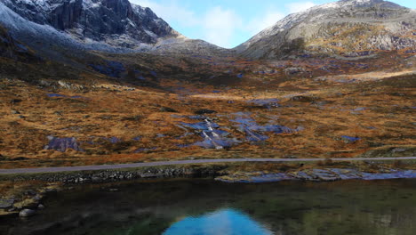 Droneshot-De-Noruega-Y-Una-Cascada-En-Las-Montañas-Al-Lado-De-Una-Calle