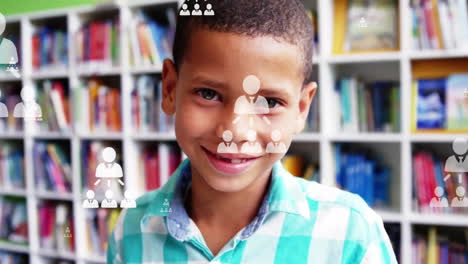 animación de iconos de perfil diagramas de flujo en primer plano de un niño biracial sonriente de pie en la biblioteca