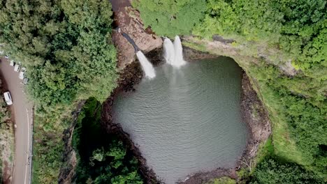 steady drone shot high above wailua falls waterfall and rainforest in kauai, hawaii