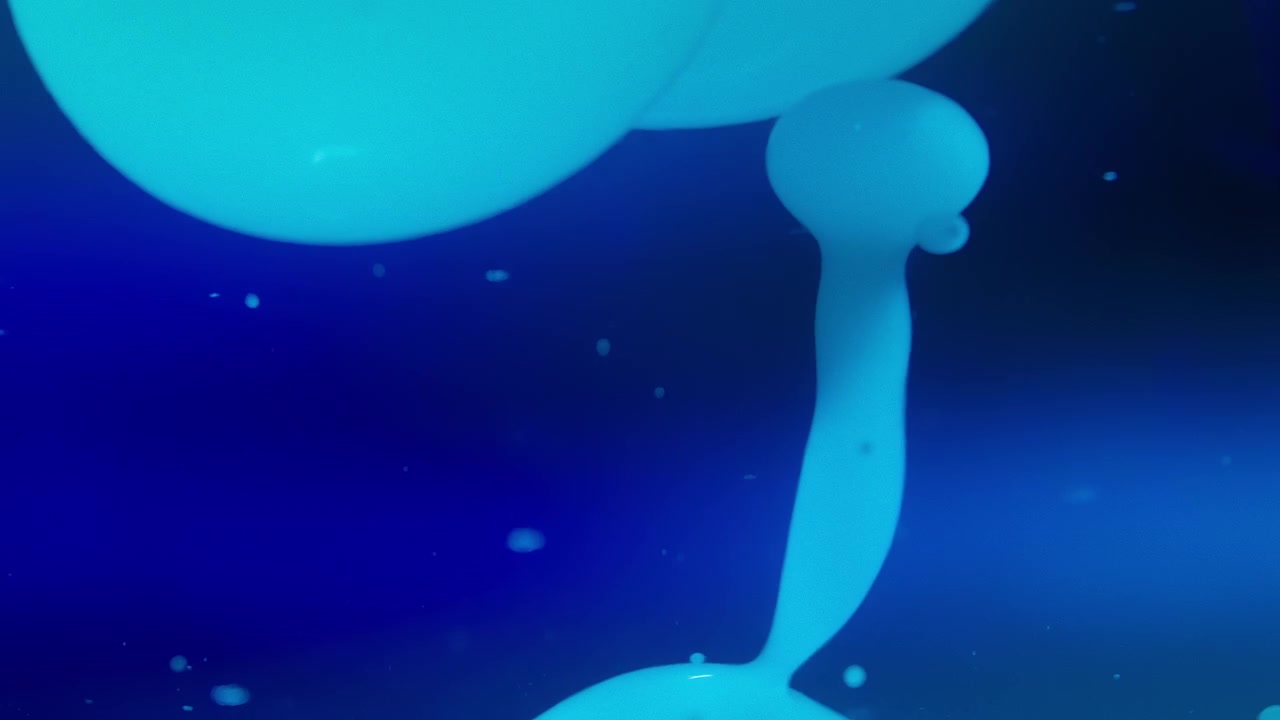 Burbujas de lava fluyendo en líquido sobre fondo azul. Abstracto, cámara lenta.