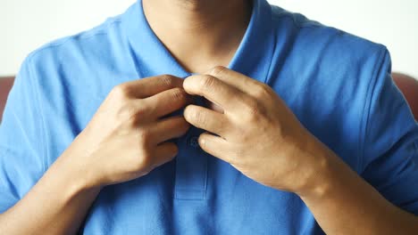 man buttoning his shirt close up