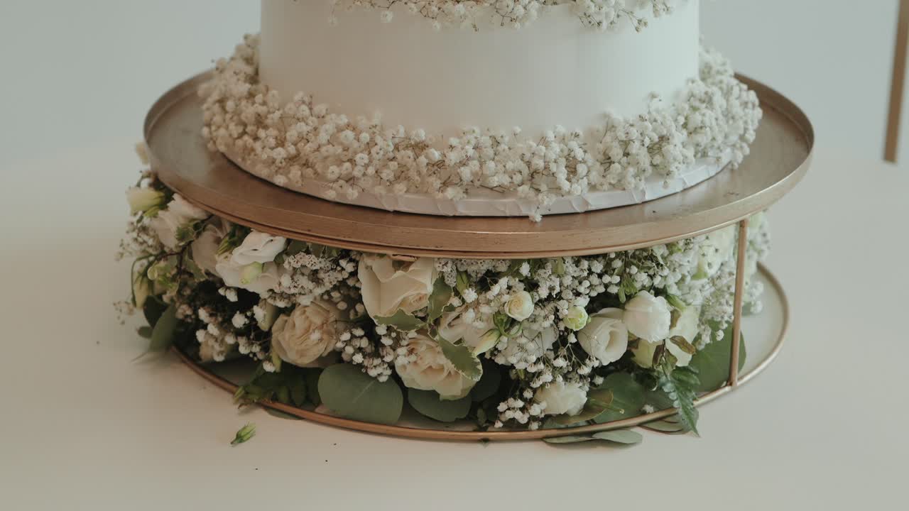 Closeup of wedding cake decorated with white roses and flowers