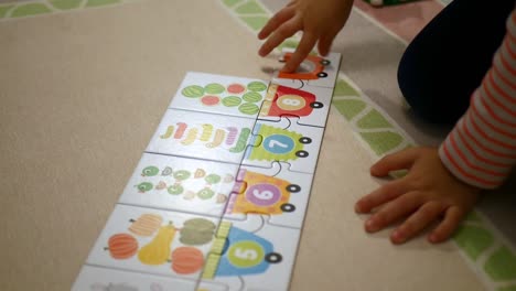 child playing with colorful puzzles with numbers learning to count