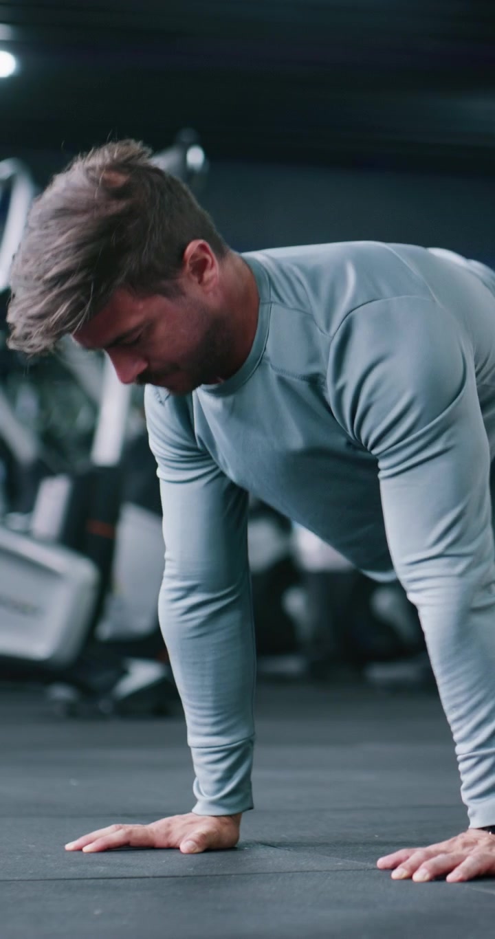 Fit Man Performing Push-Ups in a Modern Gym