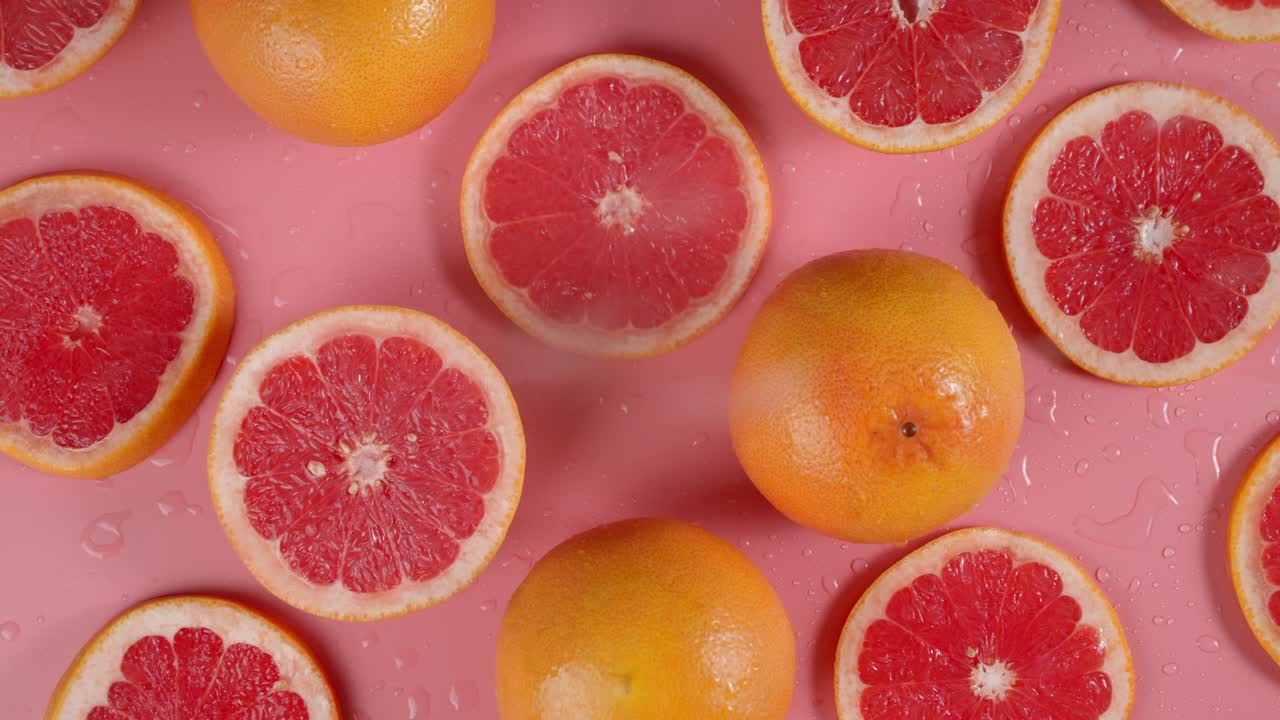 On round slices of grapefruit falling water drops.