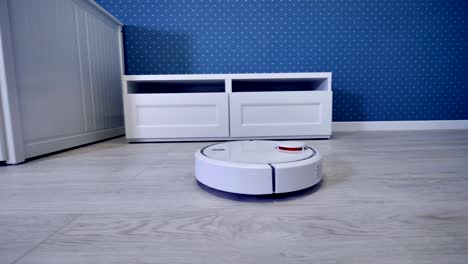 a robotic vacuum cleaner starts its routine from the door.