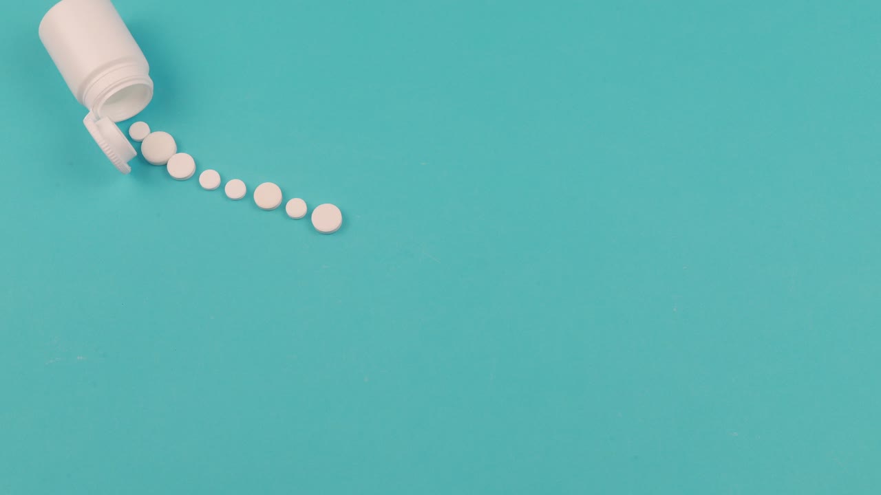 animación en stop motion de 4k de una píldora blanca sobre un fondo azul