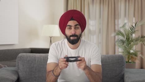 hombre indio sikh competitivo jugando videojuegos