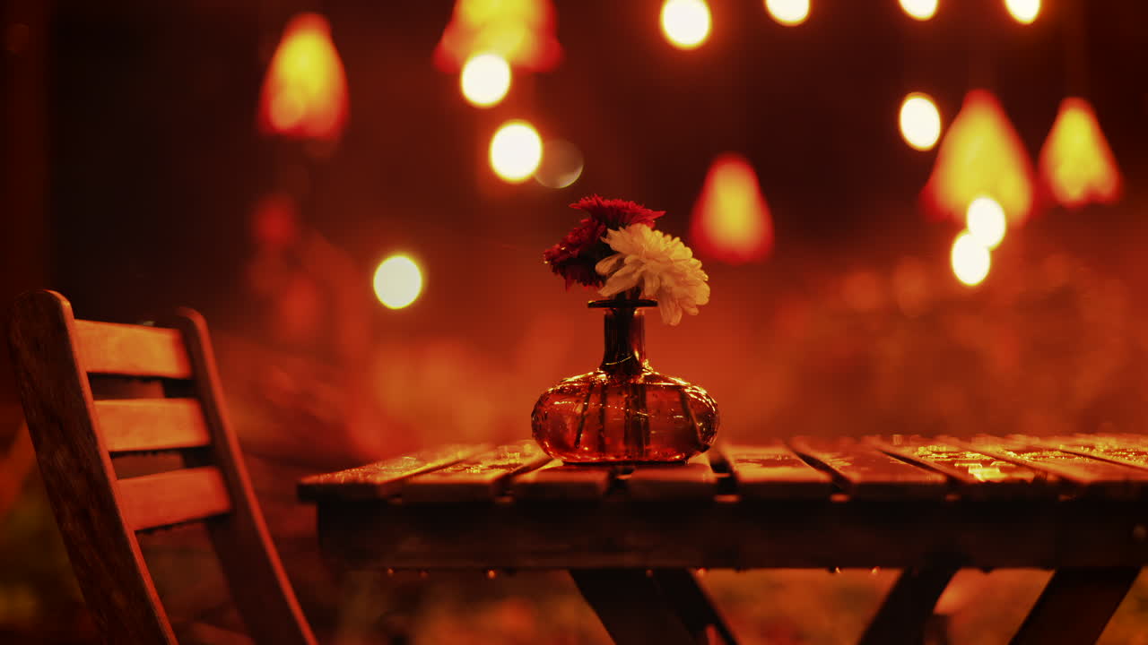 A wooden table with flowers illuminated by soft hanging lights