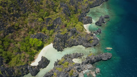 multiple outrigger boats docked at a deserted beach on snorkeling tour nearby el nido, palawan, pilippines