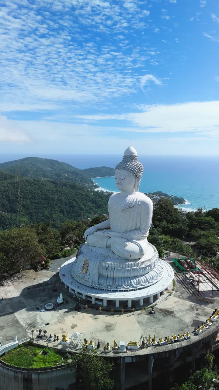 Vertical aerial approach orbits right around Phuket Big Buddha with sweeping Andaman views