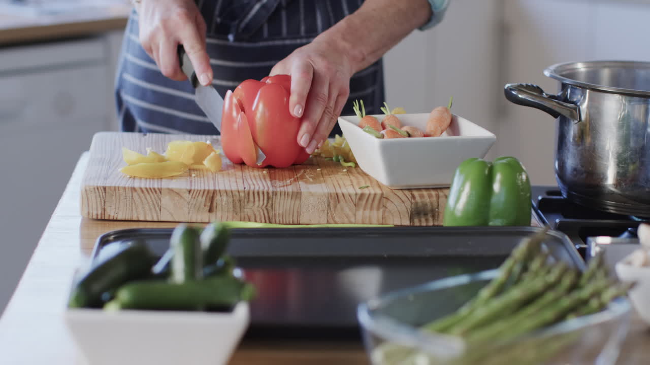 mujer caucásica de mediana edad preparando comida, cocinando en la cocina en casa, cámara lenta