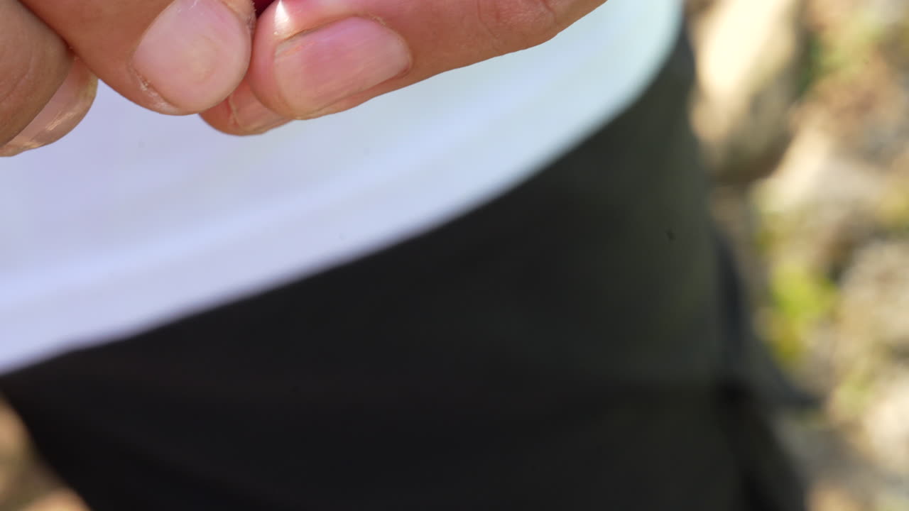 Detailed close-up shot of a farmer's hands expertly harvesting a ripe coffee cherry, showcasing the vibrant red fruit under natural sunlight with rich textures and colors