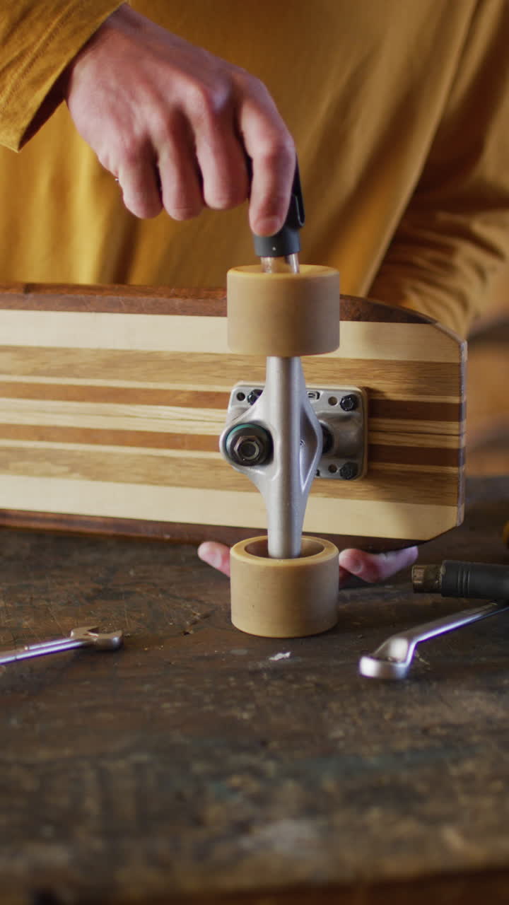 video vertical de las manos de un patinador caucásico arreglando el patinador