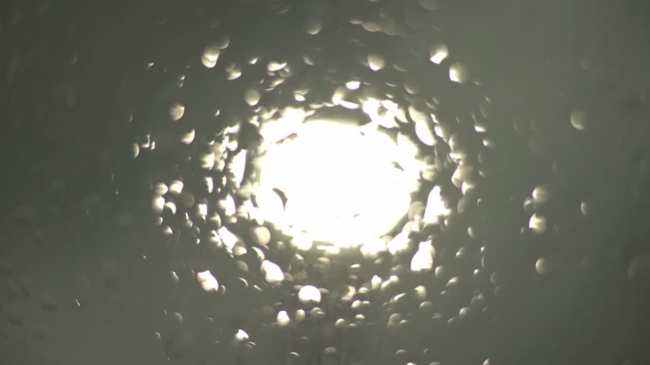 물방울이 있는 유리를 통해 보이는 빛