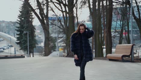 fashion outdoor video of a sexy glamour woman with dark hair wearing luxurious fur coat in autumn park.