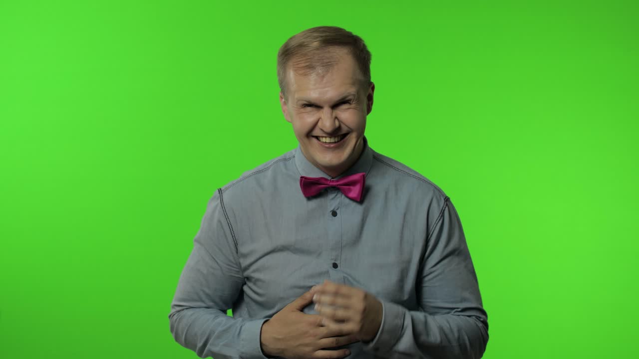 hombre sosteniendo el vientre y riendo en voz alta con lágrimas, sintiéndose despreocupado alegre después de escuchar un chiste gracioso