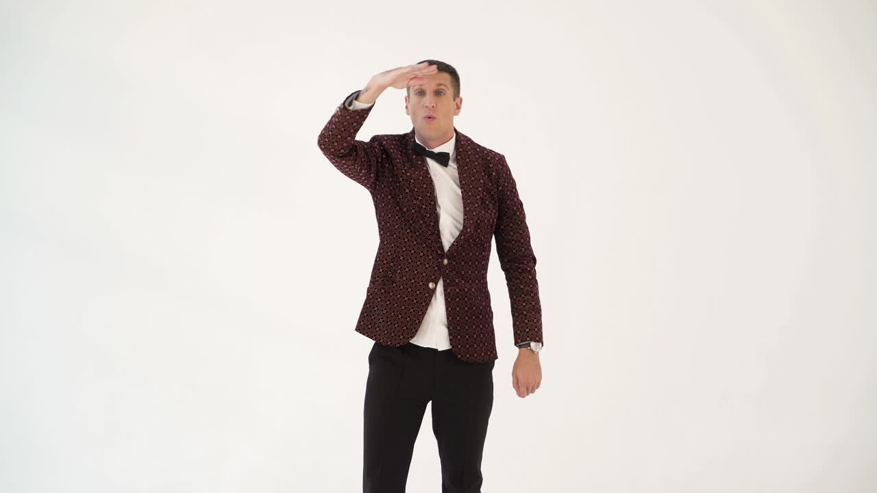 showman in a suit with a funny jacket is depicting a man who plays golf on a white background in the studio