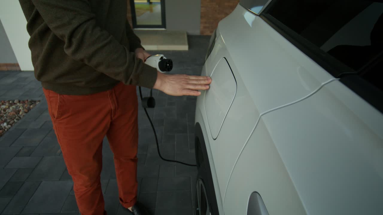 Evde Elektrikli Araç Şarj Eden Adam